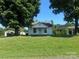 Quaint one-story home with a covered carport and lush green lawn on a sunny day at 22987 Alonzo Rd, Oakboro, NC 28129