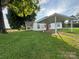 Quaint white home featuring a covered carport and a lush green lawn at 22987 Alonzo Rd, Oakboro, NC 28129