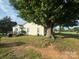 Home situated in a yard with mature trees and a wood deck at 22987 Alonzo Rd, Oakboro, NC 28129