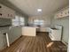 Bright kitchen with white cabinets, appliances, laminate countertops, and flooring at 22987 Alonzo Rd, Oakboro, NC 28129