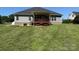 Expansive backyard featuring a well-maintained lawn, covered patio, and mature trees at 231 Glenwood Dr # 4, Oakboro, NC 28129
