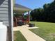 View of the backyard featuring a covered deck, outdoor grill, and lush green grass at 231 Glenwood Dr # 4, Oakboro, NC 28129