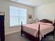 A well-lit bedroom featuring a dark wood four-poster bed and neutral walls at 231 Glenwood Dr # 4, Oakboro, NC 28129
