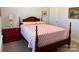 Charming bedroom features wooden bed frame, side table with lamp, and neutral carpeting at 231 Glenwood Dr # 4, Oakboro, NC 28129