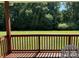 Picture perfect covered deck with wood railings and a scenic view of the lush, green lawn and trees at 231 Glenwood Dr # 4, Oakboro, NC 28129