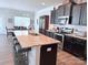 A stylish kitchen features a granite island, stainless steel appliances, and dark wood cabinetry at 231 Glenwood Dr # 4, Oakboro, NC 28129