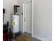 Utility room featuring an electric water heater, concrete floor, and access to the exterior at 231 Glenwood Dr # 4, Oakboro, NC 28129