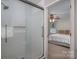 Bright bathroom boasts a glass enclosed shower with white tile and a view into the bedroom at 2410 Monticello Dr, Gastonia, NC 28056