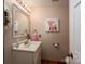 Charming half bathroom with classic fixtures, vanity, and a decorative mirror and artwork at 2410 Monticello Dr, Gastonia, NC 28056