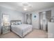 Neutral bedroom with two windows, ceiling fan, and a side table with a lamp on a plush carpet at 2410 Monticello Dr, Gastonia, NC 28056