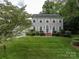 Two-story home with well-maintained lawn, complemented by lush green landscaping and mature trees at 2410 Monticello Dr, Gastonia, NC 28056