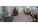 Cozy living room features a plush grey recliner, carpeted floors, and a small round table with wicker chairs at 2410 Monticello Dr, Gastonia, NC 28056