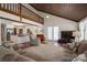 Bright living area featuring an open floorplan with wood-paneled ceiling, a kitchen, and access to the upper level at 2410 Monticello Dr, Gastonia, NC 28056