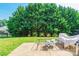 View of a backyard featuring a concrete patio and lush trees, with a small part of the house visible at 2476 Glyncastle Way, Gastonia, NC 28056