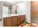 Well-lit bathroom featuring a double sink vanity with wood cabinets and a large mirror at 2476 Glyncastle Way, Gastonia, NC 28056