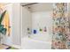 Bright bathroom with a white tiled shower and a floral shower curtain next to a towel rack at 2476 Glyncastle Way, Gastonia, NC 28056