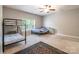Bright bedroom with carpet floors, ceiling fan, bunk bed, and a queen bed at 2476 Glyncastle Way, Gastonia, NC 28056