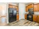 Well-equipped kitchen with wood cabinets, modern appliances, and laminate wood flooring at 2476 Glyncastle Way, Gastonia, NC 28056