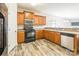 Functional kitchen featuring wood cabinets, modern appliances, and laminate wood flooring at 2476 Glyncastle Way, Gastonia, NC 28056