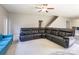 Spacious living room with a large comfortable sofa, fan and view to staircase at 2476 Glyncastle Way, Gastonia, NC 28056