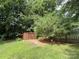 Private backyard with mature trees, a storage shed, and a well-maintained lawn at 2511 Old Pond Dr, Lincolnton, NC 28092