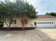 Attached garage with a multiple-paneled door, complemented by neat landscaping and mature trees at 2511 Old Pond Dr, Lincolnton, NC 28092