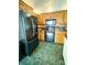 Well-equipped kitchen with wooden cabinetry, black appliances, and green tile flooring at 2511 Old Pond Dr, Lincolnton, NC 28092