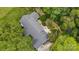 An aerial view reveals the backyard with patio, green lawns and mature trees at 307 Dogwood Dr, Mount Holly, NC 28120