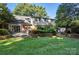 The backyard showcases a manicured lawn, patio area, and lush landscaping at 307 Dogwood Dr, Mount Holly, NC 28120