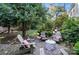 Inviting backyard with a charming stone fire pit and Adirondack chairs at 307 Dogwood Dr, Mount Holly, NC 28120