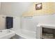 Bright bathroom features a tub with yellow floral wallpaper accenting the wall at 307 Dogwood Dr, Mount Holly, NC 28120
