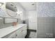 Charming bathroom featuring patterned wallpaper, vintage-style vanity, and tiled shower, offering a unique design aesthetic at 307 Dogwood Dr, Mount Holly, NC 28120