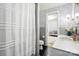 Stylish bathroom featuring wallpaper and a white shower curtain at 307 Dogwood Dr, Mount Holly, NC 28120