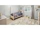 Well-lit bedroom with neutral walls, a plush area rug, and a cozy twin bed with a patterned bedspread at 307 Dogwood Dr, Mount Holly, NC 28120