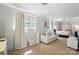 Bright bedroom with large windows, a cozy sofa, and a bed at 307 Dogwood Dr, Mount Holly, NC 28120