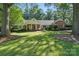 Beautiful brick home with mature trees and lush green lawn at 307 Dogwood Dr, Mount Holly, NC 28120