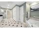 Well-lit bathroom featuring a soaking tub, tiled floors, white cabinets and trim, and green-painted walls at 307 Dogwood Dr, Mount Holly, NC 28120