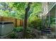 Landscaped backyard with a wooden fence, mature tree, and an exterior staircase at 310 25Th Nw Ave, Hickory, NC 28601