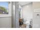 Bathroom with tall cabinet, white toilet, wooden floors, and natural light from two windows at 310 25Th Nw Ave, Hickory, NC 28601