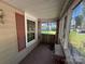 View of a screened-in porch with window and shutter on a sunny day at 310 E Division Ave, East Spencer, NC 28039
