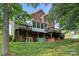 Back exterior view of brick home with multiple decks and a screened porch, nestled on a green lawn at 322 Oakview Dr, Salisbury, NC 28146