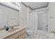 Bright bathroom featuring a white shower curtain, neutral tile, and warm-toned vanity with large mirror at 322 Oakview Dr, Salisbury, NC 28146