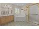 Bright bathroom featuring a soaking tub, glass shower, and double vanity with large mirrors and neutral tile flooring at 322 Oakview Dr, Salisbury, NC 28146
