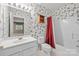 Bathroom with floral wallpaper, white vanity, and shower-tub combination at 322 Oakview Dr, Salisbury, NC 28146