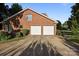 Two-car garage with a brick exterior, a long driveway, and mature landscaping at 322 Oakview Dr, Salisbury, NC 28146