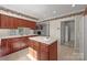 Well-lit kitchen featuring a central island with sink, wood cabinets, and view of an adjacent room with fireplace at 322 Oakview Dr, Salisbury, NC 28146