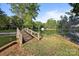 Charming wooden bridge leading to a serene pond, surrounded by lush foliage and a quaint gazebo at 322 Oakview Dr, Salisbury, NC 28146