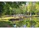 Picturesque wooden bridge over a calm pond, surrounded by lush greenery and trees, offering a peaceful setting at 322 Oakview Dr, Salisbury, NC 28146