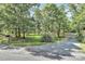 A gravel driveway leads to a vast, wooded property with scattered trees and grass at 3311 Camden Rd, Marshville, NC 28103
