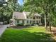 Charming two-story white brick home featuring mature trees, lush lawn and professionally landscaped flower beds at 3717 Bounty Ct, Matthews, NC 28104